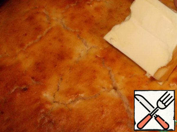 The finished cake is removed from the oven and immediately lubricated with butter. Cover with a towel and let stand for about 5-10 minutes.
