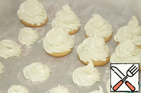 Take the gingerbread bases and put Christmas trees on them, first working with a pastry bag with a large nozzle, and then finish the work with a small one, forming the top.
If the marshmallow mass remains, then you can prepare marshmallows with the same nozzles by putting it on baking paper.