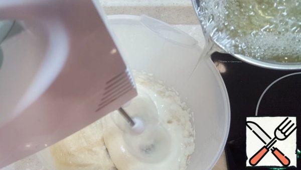 When the syrup is heated to 110 degrees, pour it in a thin stream into the puree.
