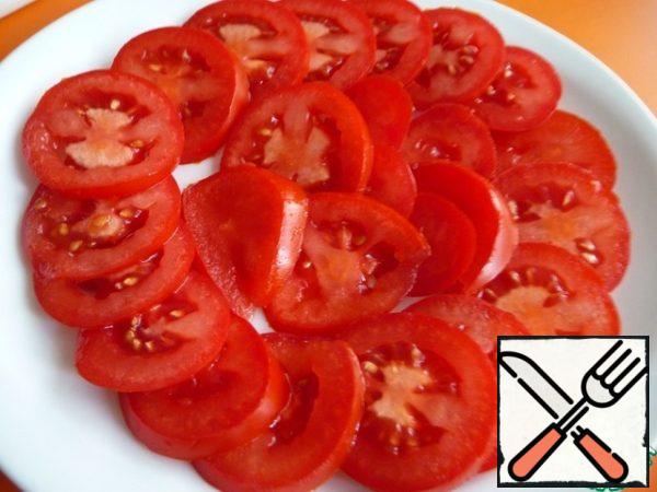 Tomatoes cut into rings (half rings), put on a plate.
