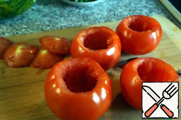 Cut the caps off the tomatoes, do not throw them away. Carefully remove the pulp with a spoon, leaving the walls so thick that the tomatoes do not fall apart during baking. The pulp can be used to make sauce or salad dressing, we don't need it.

