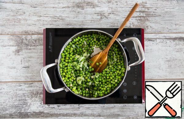 In a saucepan with a thick bottom, melt the oil and put the leek. Fry for 5 minutes. Add the herbs and stir.
Add the frozen peas, stir and warm for 3 minutes. 