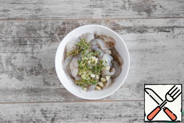 Peel the shrimp from the shell, cut it in half lengthwise, remove the dark intestinal vein. Season the shrimp with salt and pepper, add chopped garlic and thyme leaves, leave to marinate while everything else is being prepared.
