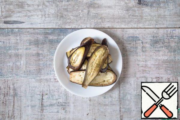 Preheat the oven to 200 °C. Cut the eggplants lengthways into slices thickness 2 see Grease them with butter, season with salt. Lay out on the laid parchment trays in one layer and put in the oven. Bake until soft and rosy, about 20 minutes.
