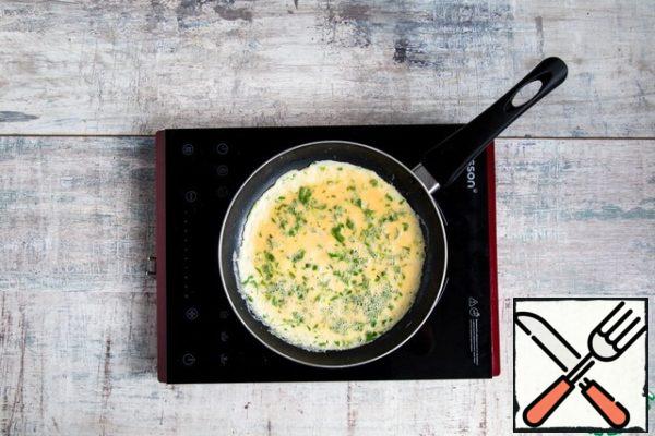 In a 22 cm diameter non-stick pan over medium heat, melt half the butter. When the butter zarenitsa, pour in the egg mixture, let stand on heat for 5-7 sec., then start vigorously stirring the contents of the pan with a spatula while shaking the pan so that the egg mass is distributed evenly. Cook this way for about 20 seconds.