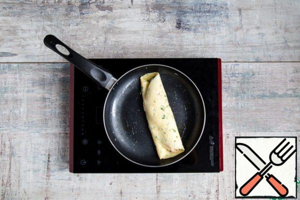 Place the filling in the center along the entire length of the omelet. Then knock the raised pan on the work surface to partially omelet "moved" sideways, and wrap the spatula "slid" part (third) to another part of the omelet, closing the filling. You should get a pointed oval.