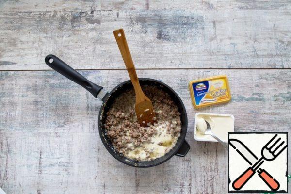 Meanwhile, preheat the oven to 160 °C. Finely chop the onion and garlic, fry in 2 tablespoons of butter for 5 minutes. Mix with minced meat, add egg and cheese, mix, season with salt and pepper.
