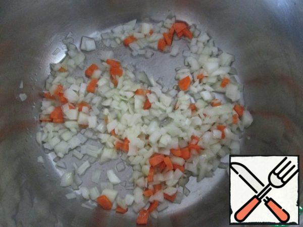 In a large saucepan (I have a 5-liter one), heat a couple of tablespoons of vegetable oil over medium heat and fry finely chopped onions and carrots. Fry for a short time, until the onion is transparent.

