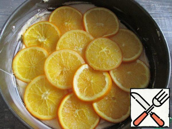 Sift flour, semolina, baking powder and salt into a bowl. Combine flour and oil-egg mixture. Grease the molds with a diameter of 24 cm with butter, pour into it the dough. Top spread slightly overlap the welded rings of oranges. Put the cake in the oven for 15 minutes. Then reduce the temperature to 175 degrees and bake for another 30-40 minutes.