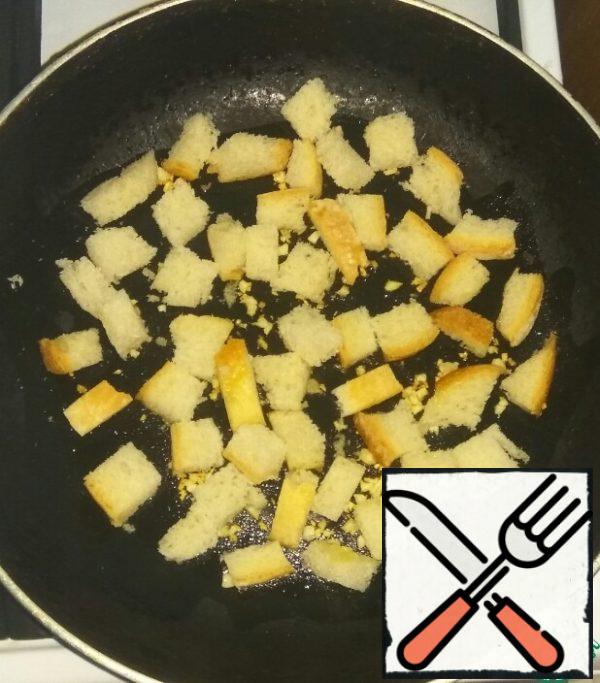 Add sliced bread to the garlic. Fry the crackers on all sides until golden brown.
