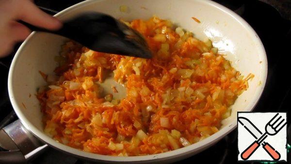 Meanwhile, finely chop the onion, grate the carrots on a fine grater and fry everything in vegetable oil.