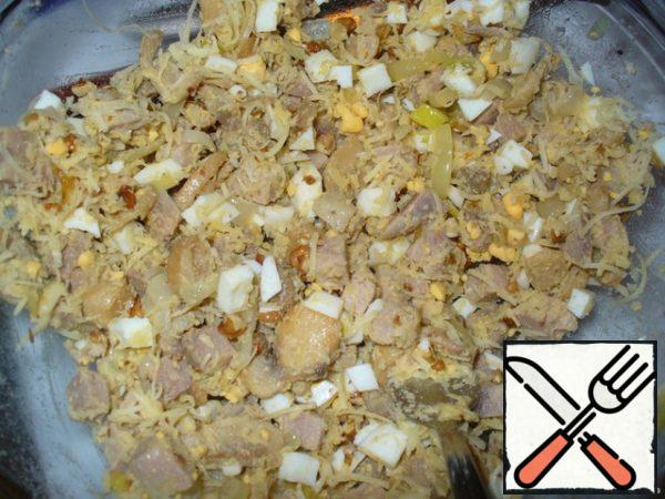 Boil hard-boiled eggs. Cut them in cubes. In the salad bowl mix the cubes of pork, fried mushrooms with onions, eggs, grated cheese and chopped walnuts.