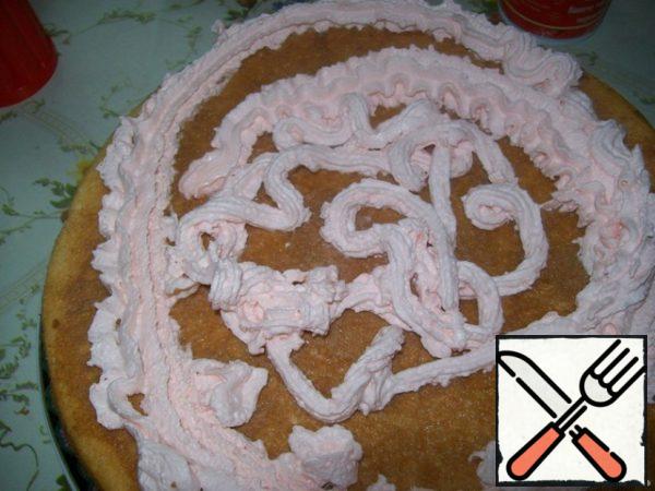 Unfortunately, in the shops of our town you can find cream only 10-15 % fat, and they, well, do not want to whisk, so I decided to replace them already whipped cream from a can (I was strawberry).
Cream apply to the first cake and spread them over the entire surface.