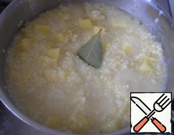 Add potatoes and onions to the millet groats. We send the bay leaf to them. Cook for another 10 minutes.
