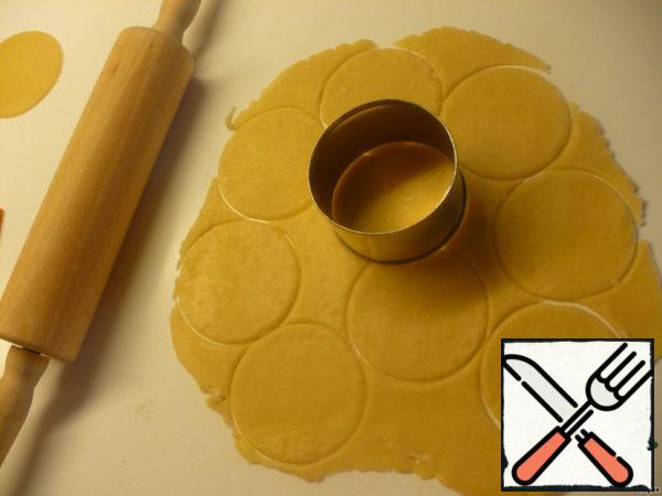 After half an hour, take out the dough, roll it into a layer and cut out the circles.
