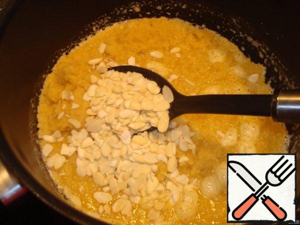Meanwhile, put the butter, peeled almonds and finely chopped semolina in another saucepan. Fry on medium heat for about 5 minutes, stirring constantly, the mass will swell.
