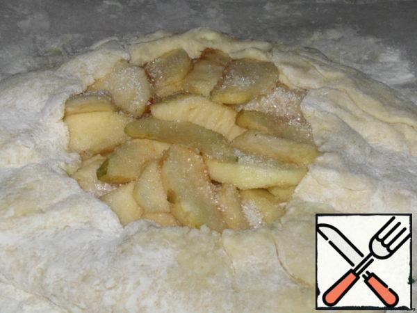 Apples sprinkle with sugar and cinnamon and wrap the edges of the dough, as in the photo.