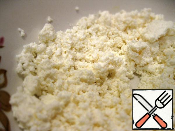 While the dough is defrosting, prepare the filling: put the cottage cheese (or grated cheese) in a deep bowl.
