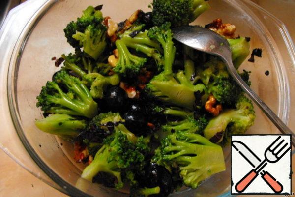 Mix broccoli with olives, nuts, Basil and season with dressing.