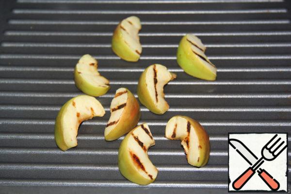 Apples spread on a frying pan grill and fry on 2 sides.