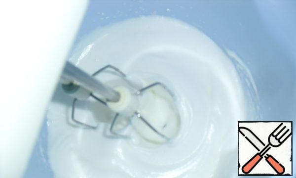 In another bowl, whisk the whites, gradually adding the remaining sugar until a thick, stable mass is formed.
