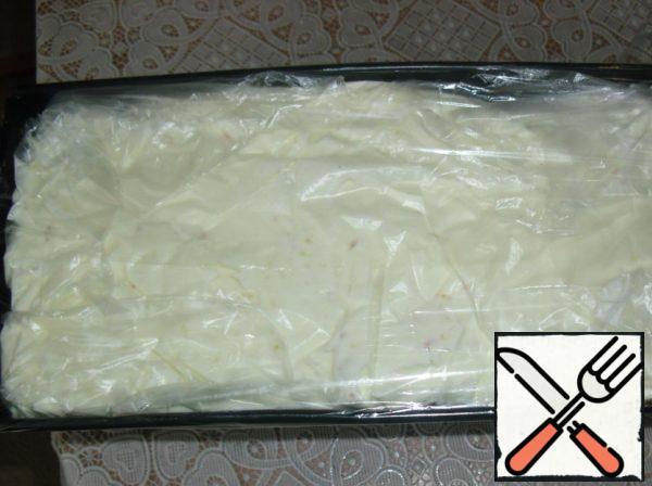 Cover the mold evenly with plastic wrap so that the ends hang down.
The mixture is spread into a mold. Silicone molds can also be used.
Cover with plastic wrap and put in the freezer for at least 12 hours.