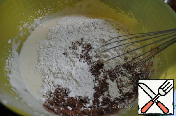 Now sift the flour into the dough with baking powder, salt and cocoa. Knead the dough: it should turn out not thick.