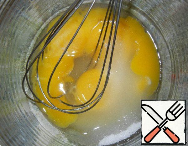 Beat until a strong foam egg yolks, fructose and 3 tablespoons of hot water.
