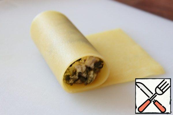 Roll it into a tube. Repeat this step until you run out of lasagna sheets and minced meat.
