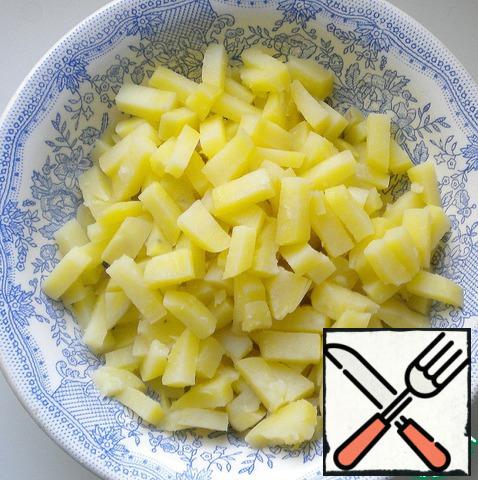 Boil the potatoes in their skins, cooled and cut into approximately cubes.