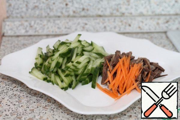 Cut into strips boiled tongue, raw cucumber and some carrots.