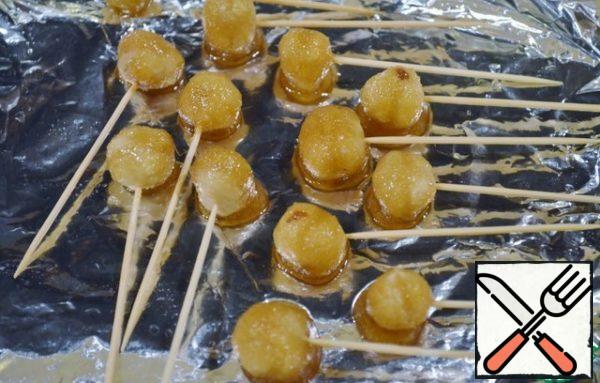 Dip the nuts into the slightly cooled caramel (it should cool down and become quite viscous), let it drain and put it on a greased foil. Let it freeze.
