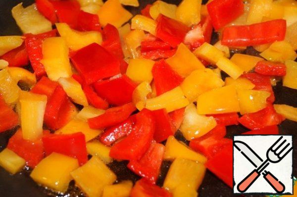 In the remaining oil, simmer the diced (1 cm) pepper for 2-3 minutes. Put it to the zucchini. Leave the oil.

