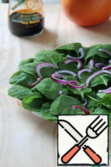 Put spinach on a plate, then onion.