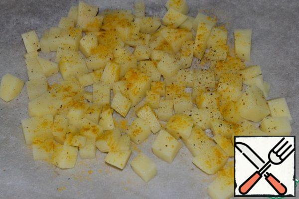 Cut the potatoes into cubes and place them on a baking sheet covered with baking paper, greased with olive oil. Sprinkle with a mixture of turmeric and pepper, add salt. Bake in the oven at 170 degrees for 35-40 minutes.
