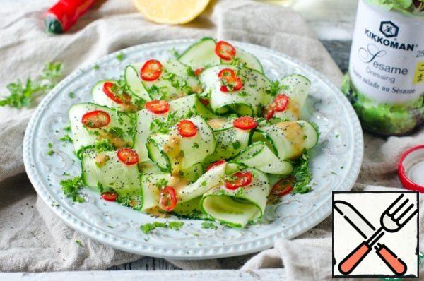Put cucumbers on the plates, sprinkle with red pepper and finely chopped parsley.
Sprinkle the salad with olive oil, lemon juice, sesame sauce and sprinkle with poppy seeds.
Salad salt is not necessary, since the sauce already has salt.
That's it, our salad's ready.