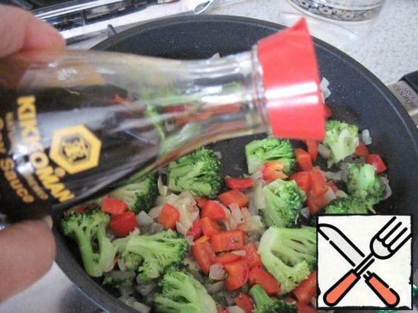 Add broccoli and stew under the lid for 2-3 minutes, pour the soy sauce and keep on fire for another minute.