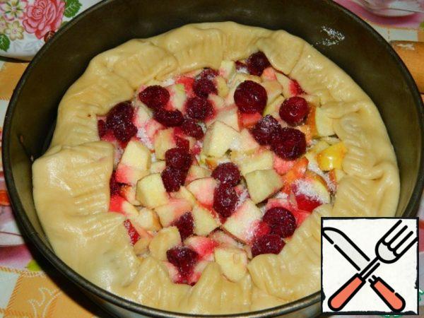 The dough is rolled into a large circle in the middle spread chopped apples and cherries. Sprinkle with sugar. Turn the sides of the dough to the filling. Bake in a preheated oven at 200 degrees for 30 minutes.

