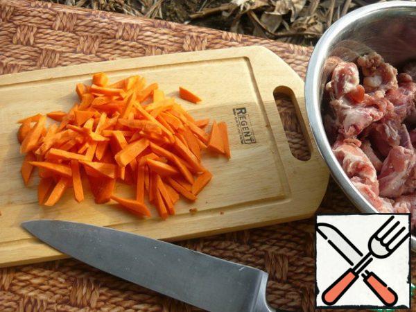 We make a fire and, while it burns, cut carrots into large cubes.
