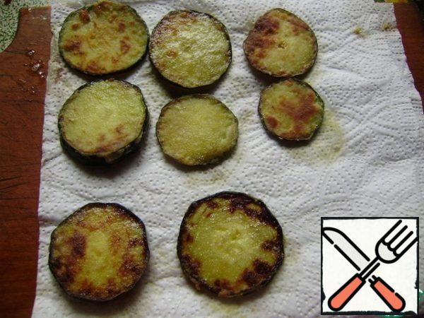 Fried zucchini spread on a paper towel to remove excess oil.