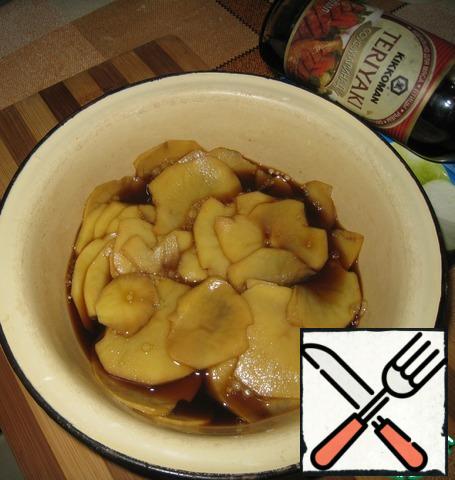 Potatoes are cleaned, cut into thin slices, pour the sauce-marinade teriyaki Kikoman. Leave to marinate for 2 hours.