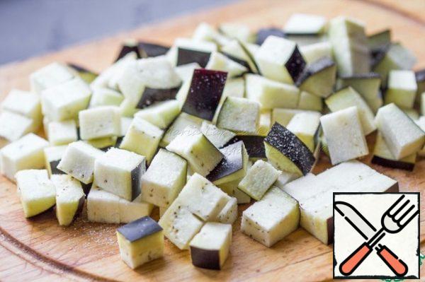 While the dough is resting, prepare the vegetables and put them to bake. Cut the eggplant into cubes, sprinkle with salt and set aside for 5-10 minutes.