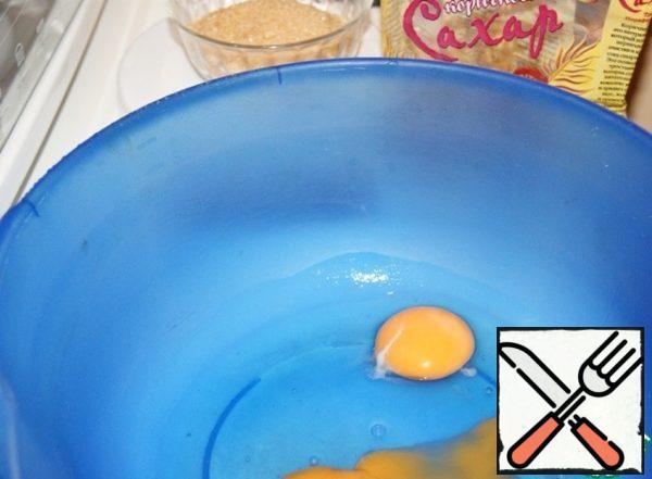 Beat 2 eggs to increase the volume 3 times and, without ceasing to beat, enter 100 g of brown sugar.