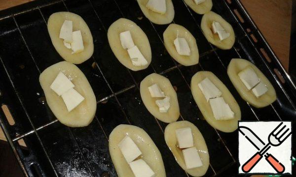 Dip potatoes in a mixture of soy sauce, vegetable oil, starch and spices. Lay out on bars. Put in the center pieces of processed cheese.