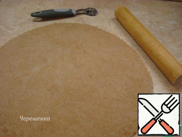 Sprinkle the table with wheat flour, roll out the dough with a diameter of about 40 cm, a thickness of about 5 mm.If you want to add beauty to the dish, then cut the dough along the edges with a curly pizza knife, using a large plate to make an even circle. Place a circle of dough on a baking sheet lined with parchment... I have a silicone mat, but then I regretted that I didn't take the parchment, because then it's easier to transfer the galette to a dish…

