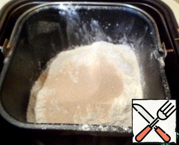 Put all the ingredients for the dough in the bread maker and turn on for 2 hours on the "Dough" mode.