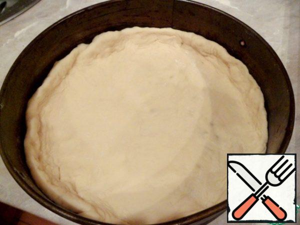One half of the dough is rolled into a thin pancake and put, forming the bumpers, in a greased form.