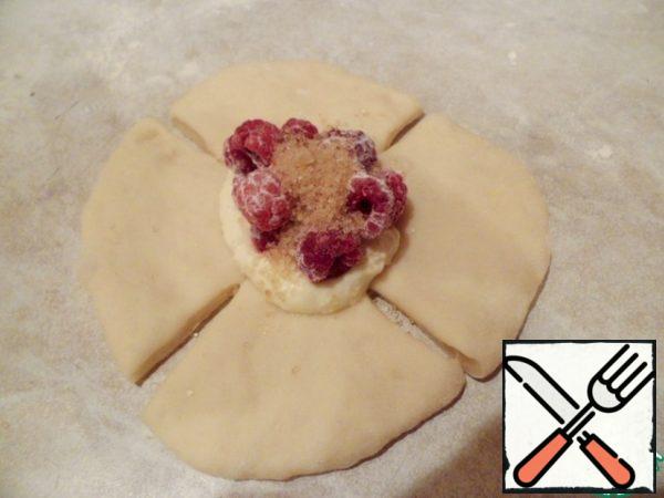Make crimson roses. Each bun roll out and make the edges of the 4 incision criss-cross, not reaching the middle. In the middle put a teaspoon of cottage cheese, it-raspberries, and sprinkle with brown sugar.