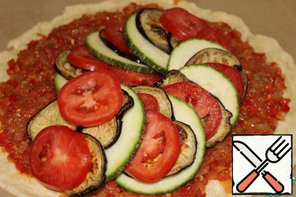 Lay out, alternating, slices of vegetables on the sauce so that they form a spiral - from the middle to the edges of the dough.
