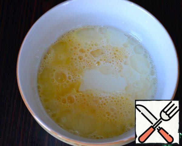 Beat the egg lightly with a fork, add the remaining milk, vegetable oil and 1/3 teaspoon of salt. Mix well.